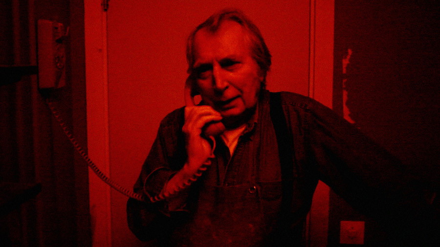 Jean Hermansson talar i telefon i ett mörkrum med röda lyset påslaget