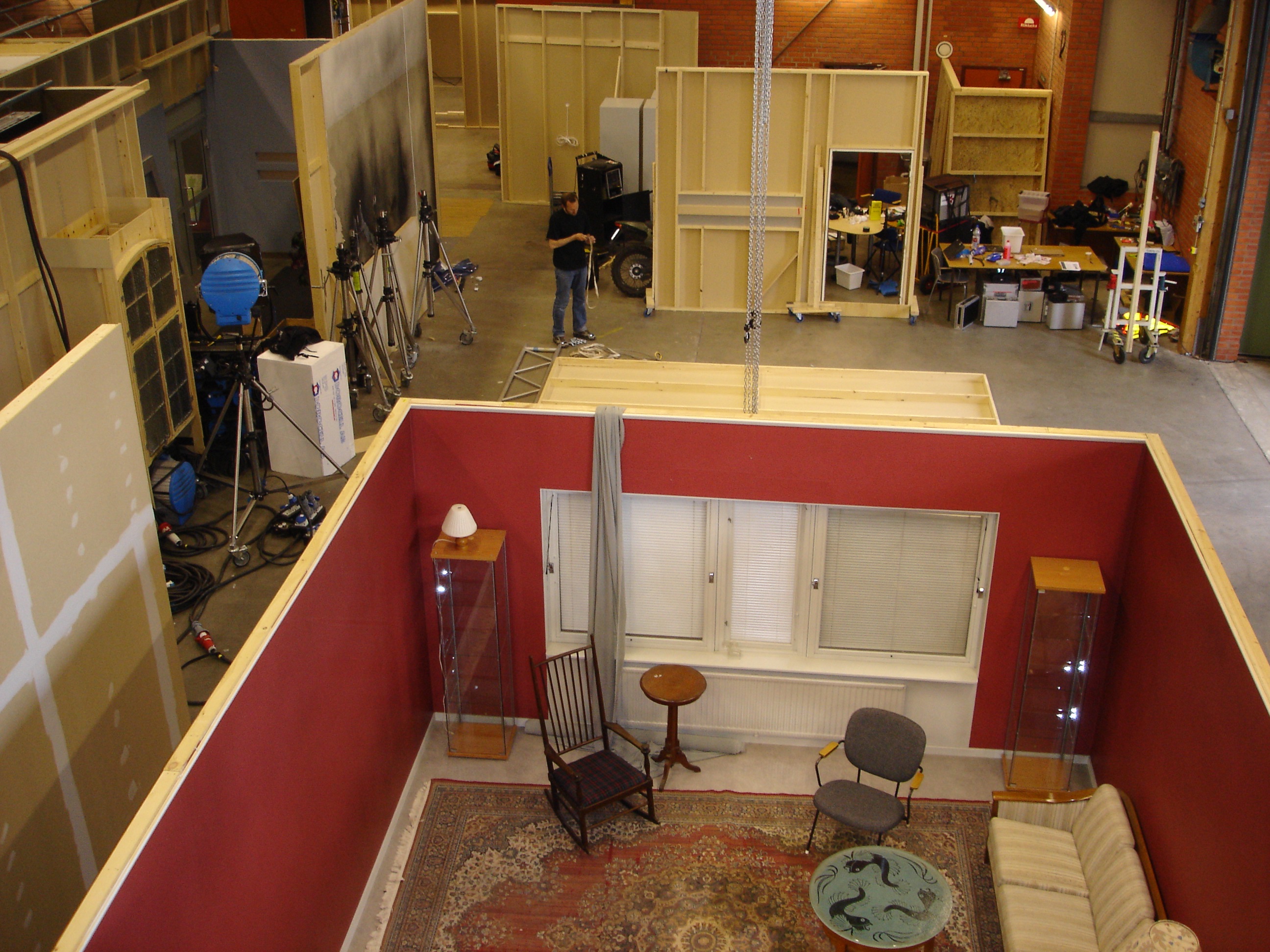 Foto ovanifrån på filmscenografi inne i Ystad Studios. Ett vardagsrum är uppbyggt.