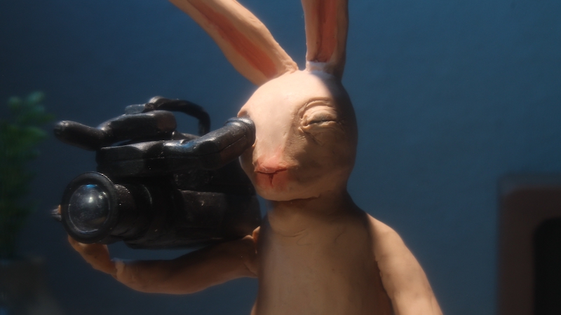 En animerad kanin filmar med en filmkamera.