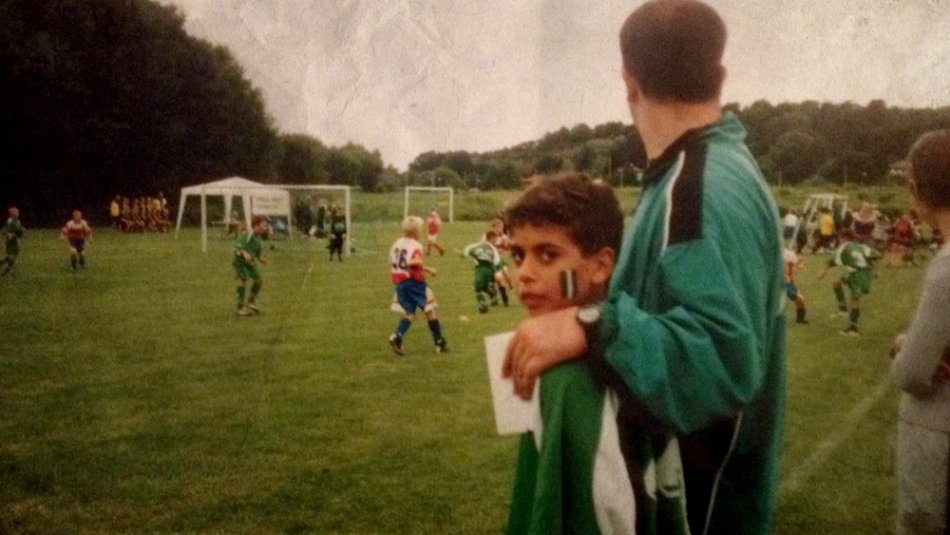 Filmfoto från Brev till en seriemördare. En pojke står invid en fotbollsplan, tittar in i kameran.