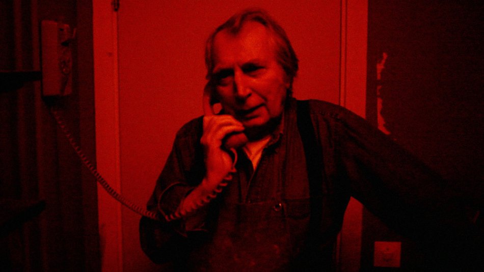 Fotografen Jean Hermansson i mörkrummet. Filmbild ur Himlens mörkrum.