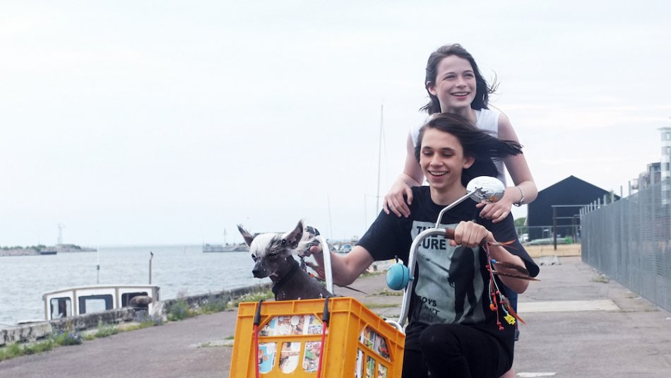 Två tonåringar på en cykel i hamnen. Filmfoto ur Det borde finnas regler.