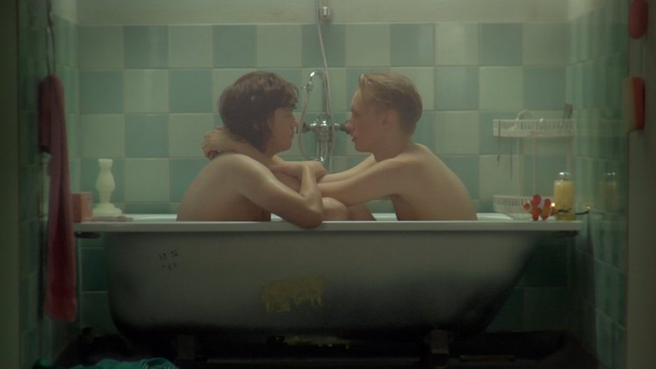 Två personer sitter vända mot varandra i ett badkar. Ur filmen Pojektanten.